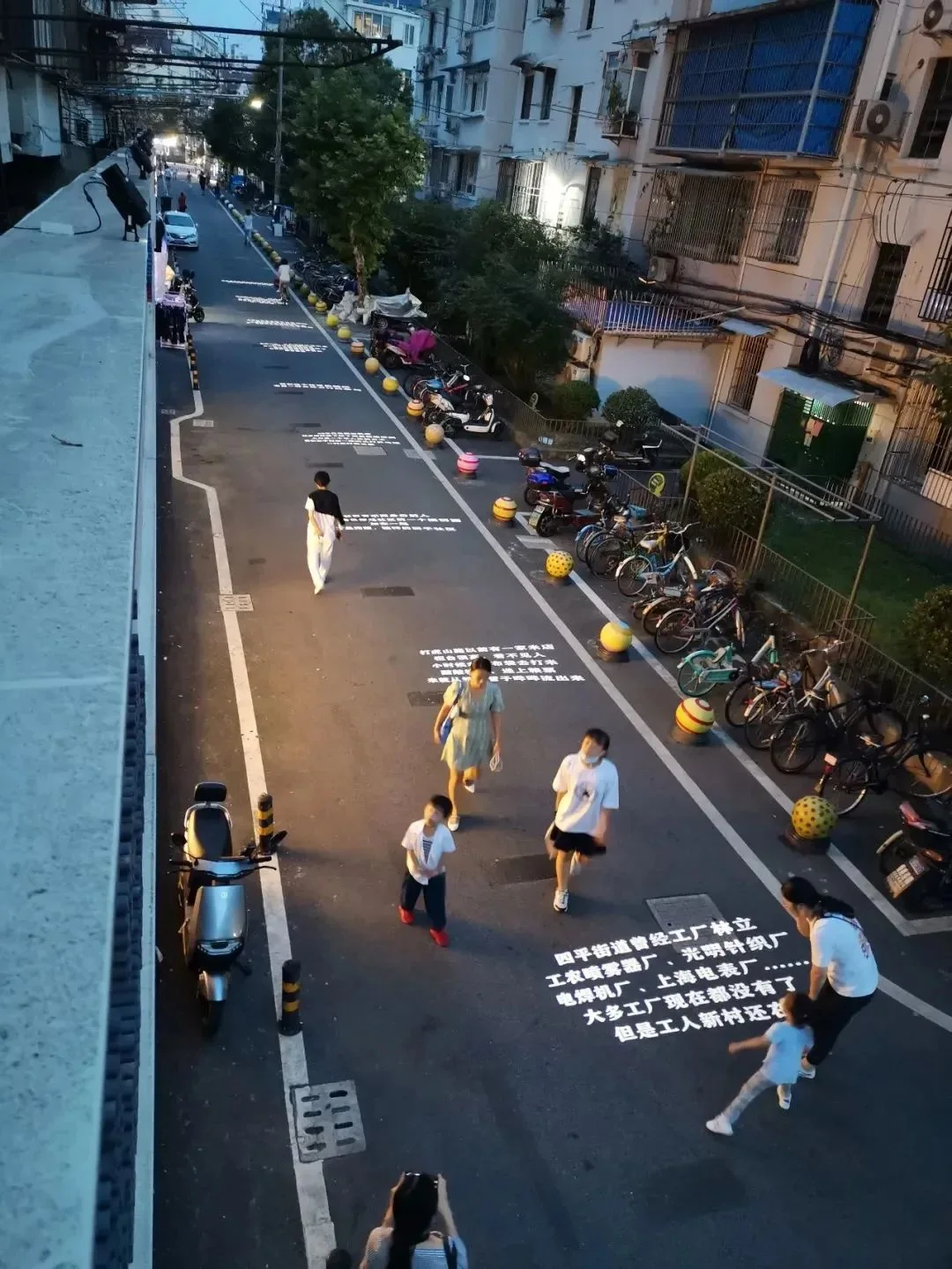 People walking along Poetry One-Way Street with illuminated poems on the road